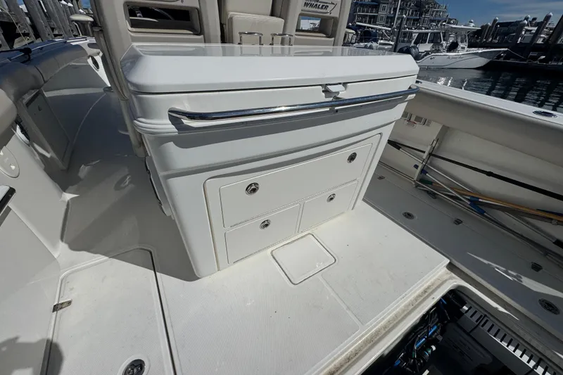 Slide: The Image of 2019 Boston Whaler 330 Outrage boat interior with storage compartments and seating. - 12