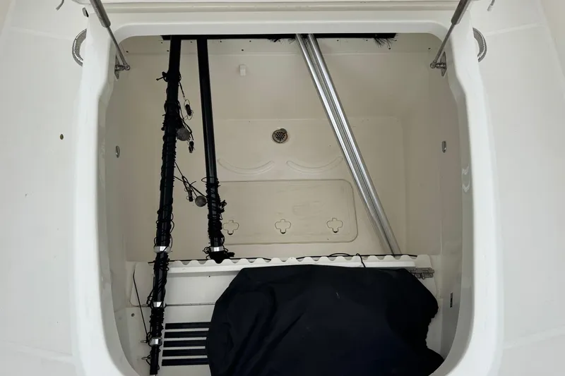 Slide: The Image of Storage compartment of a 2019 Boston Whaler 330 Outrage boat, featuring fishing gear. - 15