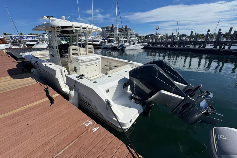 Slide: The Image of 2019 Boston Whaler 330 Outrage docked at marina with twin outboard engines. - 2