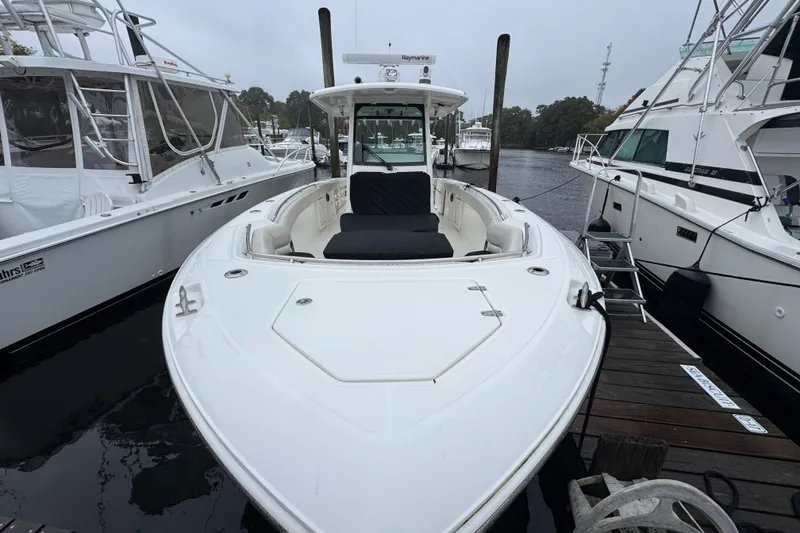 Slide: The Image of 2019 Boston Whaler 330 Outrage docked between boats on a cloudy day. - 3