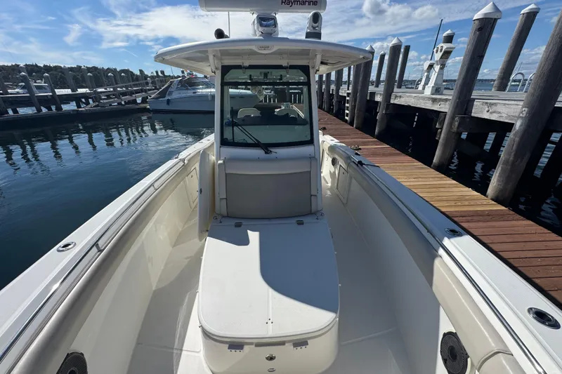 Slide: The Image of 2019 Boston Whaler 330 Outrage boat docked at marina under clear sky. - 6