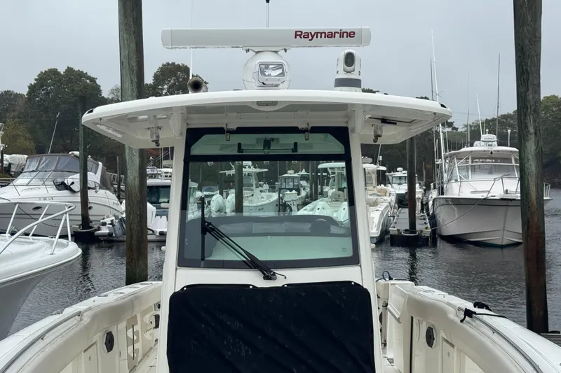 Slide: The Image of 2019 Boston Whaler 330 Outrage docked, featuring Raymarine equipment, surrounded by other boats. - 7