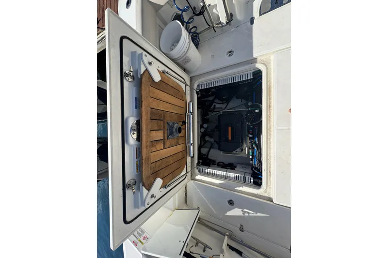 Slide: The Image of 2019 Boston Whaler 330 Outrage engine compartment with open hatch and visible equipment. - 9