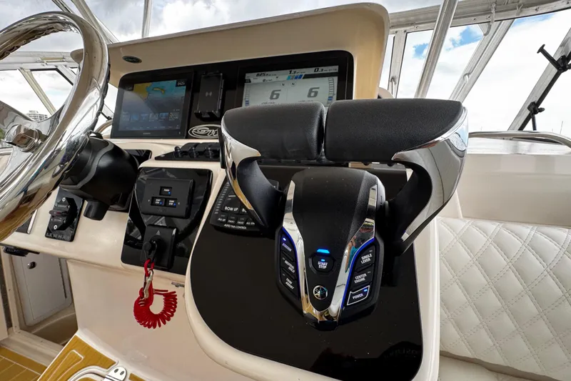Slide: The Image of Control panel of 2001 Grady-White Express 330 boat with steering wheel and throttle levers. - 41