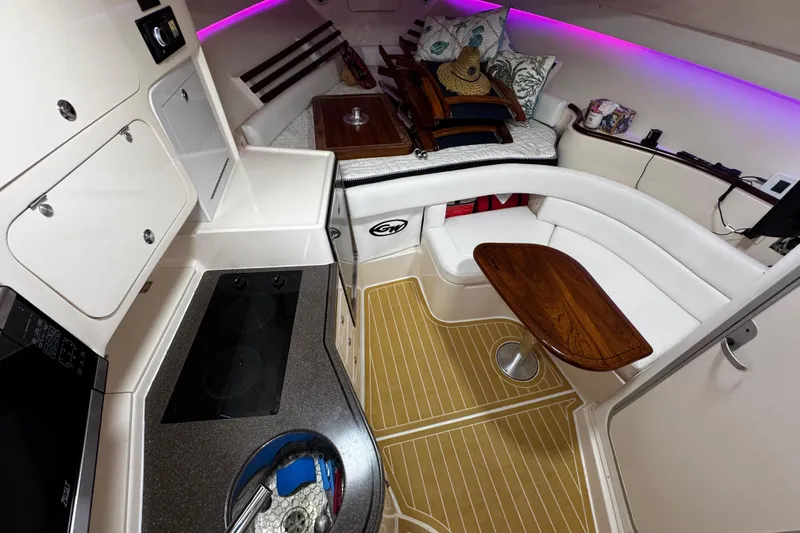 Slide: The Image of 2001 Grady-White Express 330 cabin interior with kitchenette, seating, and ambient lighting. - 66