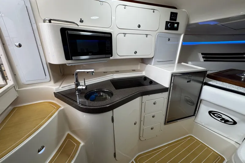 Slide: The Image of 2001 Grady-White Express 330 boat interior with kitchenette, sink, and microwave. - 67