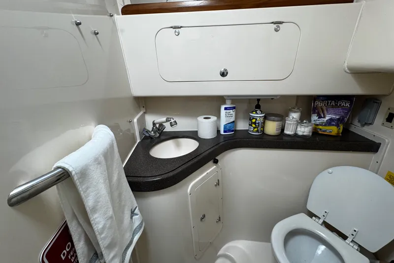 Slide: The Image of 2001 Grady-White Express 330 boat bathroom with sink, toilet, and storage cabinets. - 75