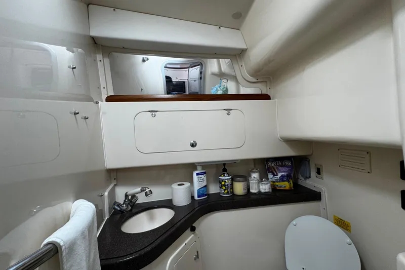 Slide: The Image of 2001 Grady-White Express 330 boat bathroom with sink, mirror, and storage cabinets. - 76