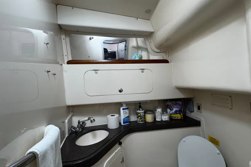 Slide: The Image of 2001 Grady-White Express 330 boat bathroom with sink, storage, and toiletries. - 77