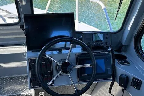Slide: The Image of 2023 Hewescraft 210 Sea Runner ET HT boat docked on calm water. - 2