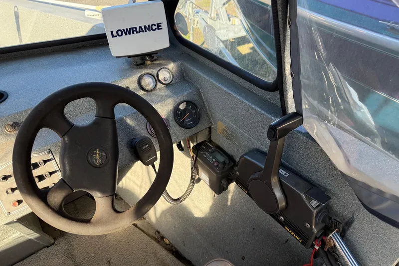 Slide: The Image of Interior of a 2000 Harbor Craft Nahanni 1925 SK boat with steering wheel and controls. - 17