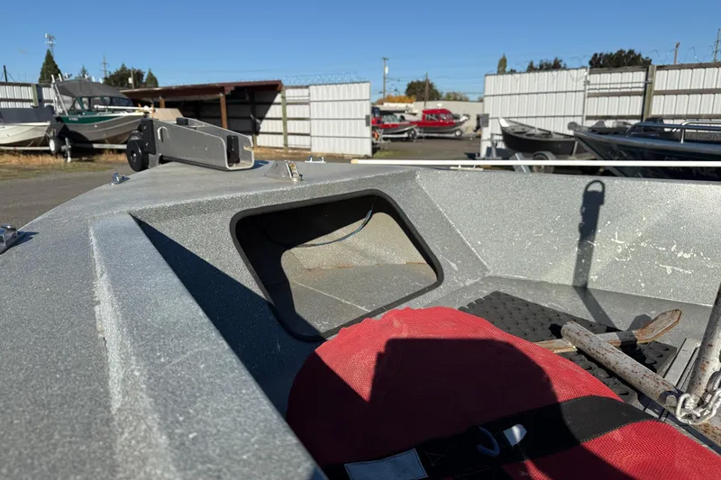 Slide: The Image of Harbor Craft Nahanni 1925 SK boat, 2000 model, with anchor and red cushion in a storage yard. - 9