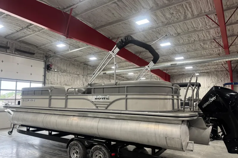 Slide: The Image of 2021 Lowe SS 270 pontoon boat in a warehouse, featuring a Mercury engine. - 3