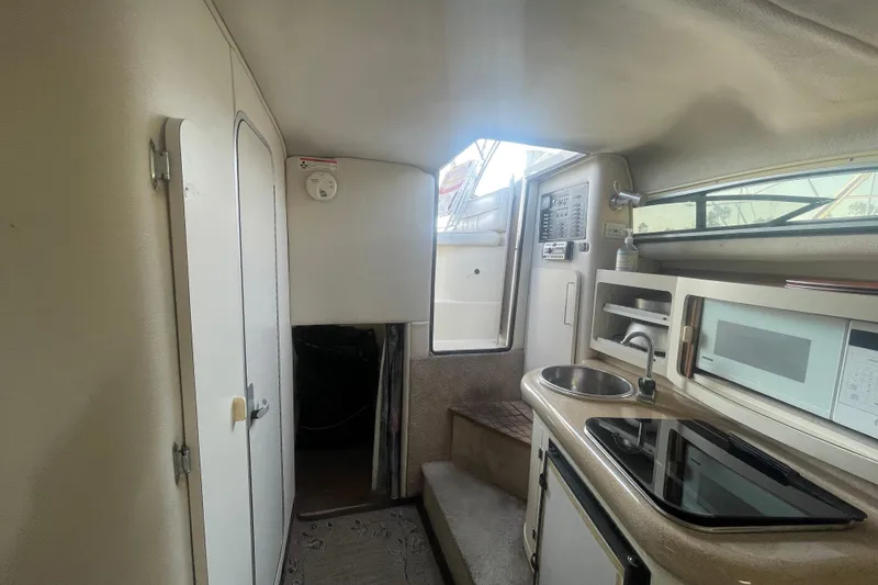 Slide: The Image of Interior of a 2001 Monterey 270 Cruiser boat with kitchenette and compact design. - 12
