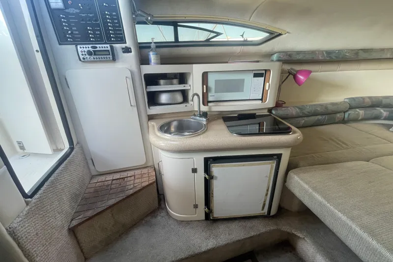 Slide: The Image of 2001 Monterey 270 Cruiser interior with kitchenette, microwave, sink, and seating area. - 13