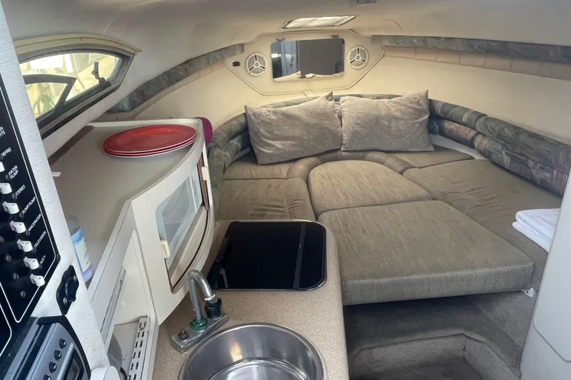 Slide: The Image of Interior of a 2001 Monterey 270 Cruiser boat with cozy seating and kitchenette. - 14