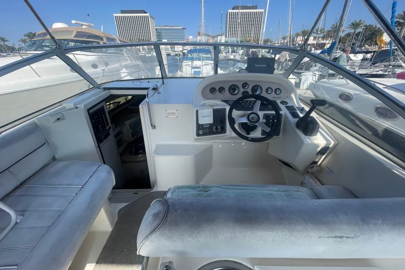 Slide: The Image of 2001 Monterey 270 Cruiser boat interior with helm, seating, and marina view. - 6
