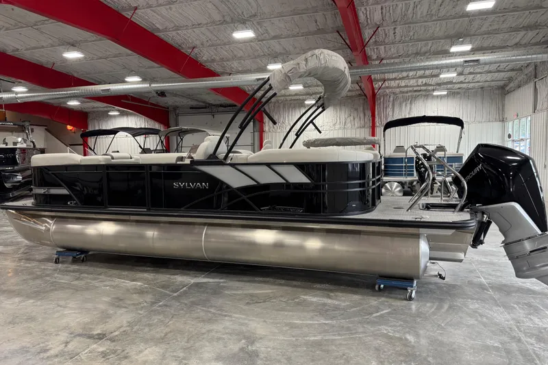 Slide: The Image of 2025 Sylvan X-5 pontoon boat in showroom, featuring sleek design and modern outboard motor. - 3
