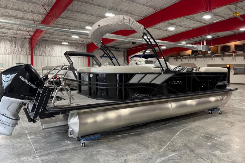 Slide: The Image of 2025 Sylvan X-5 pontoon boat in showroom, featuring sleek design and Mercury outboard motor. - 4