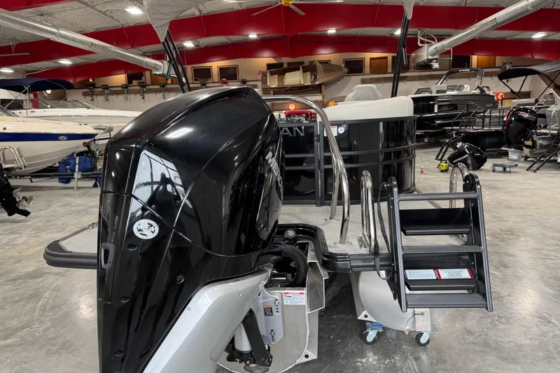 Slide: The Image of 2025 Sylvan X-5 boat in showroom with powerful outboard motor and boarding ladder. - 5