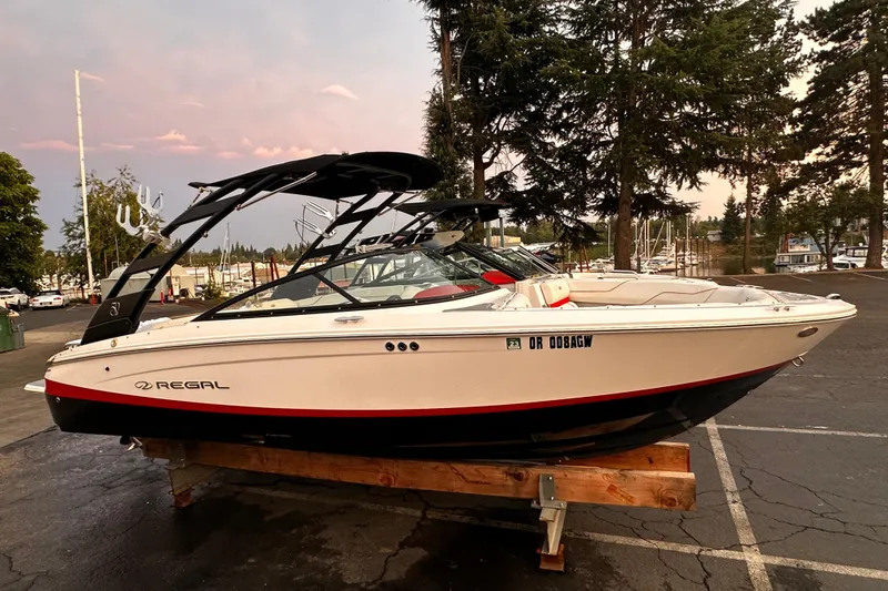 The Image of 2020 Regal LS2 Surf boat on display in a marina parking lot. - 0