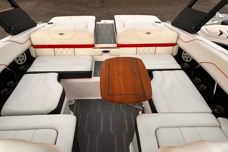 Slide: The Image of Interior of 2020 Regal LS2 Surf boat with white seating and wooden table. - 17