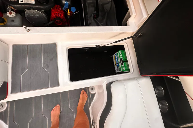 Slide: The Image of 2020 Regal LS2 Surf boat interior with open storage compartment and visible battery. - 18