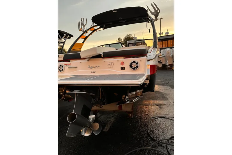 Slide: The Image of 2020 Regal LS2 Surf boat rear view at sunset, showcasing propeller and deck. - 3