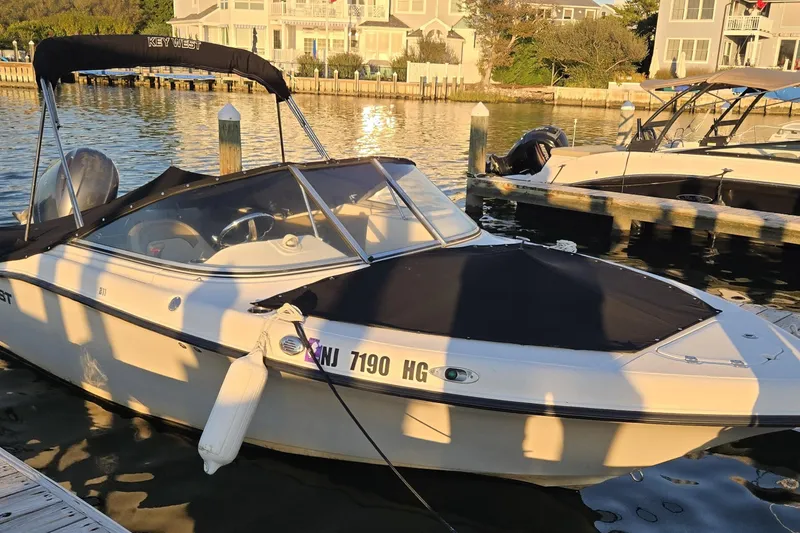 Slide: The Image of 2014 Key West 211 Dual Console boat docked at marina, sunny day. - 0
