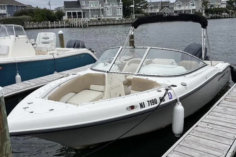 Slide: The Image of 2014 Key West 211 Dual Console boat docked at marina, featuring sleek design and comfortable seating. - 1