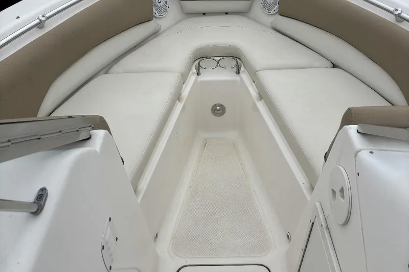 Slide: The Image of 2014 Key West 211 Dual Console boat interior with cushioned seating and storage area. - 10