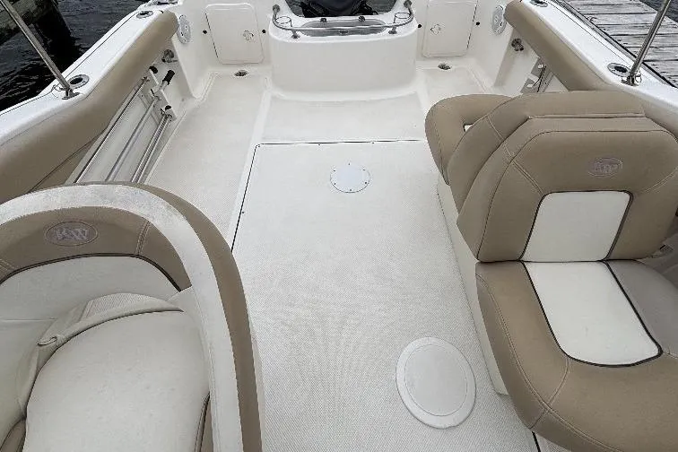 Slide: The Image of 2014 Key West 211 Dual Console boat interior with beige and white seating. - 3