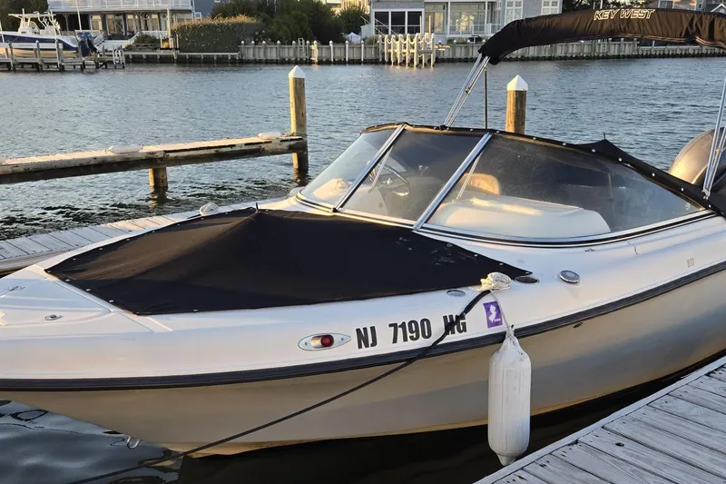 Slide: The Image of 2014 Key West 211 Dual Console boat docked by waterfront homes. - 4