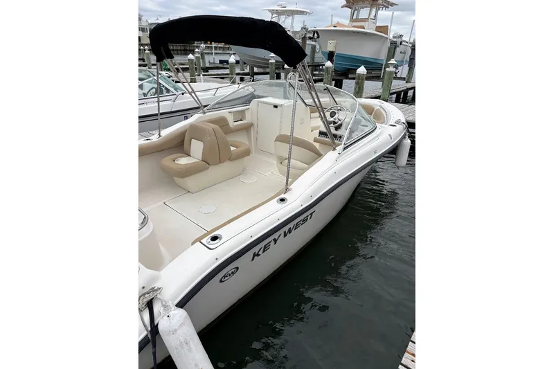 Slide: The Image of 2014 Key West 211 Dual Console boat docked, featuring spacious seating and sleek design. - 5