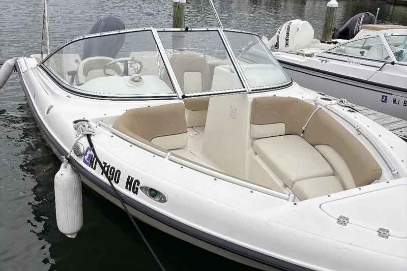 Slide: The Image of 2014 Key West 211 Dual Console boat docked, featuring spacious seating and sleek design. - 6