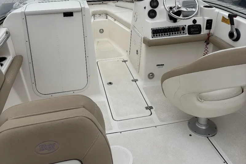 Slide: The Image of 2014 Key West 211 Dual Console boat interior with beige seating and control panel. - 7