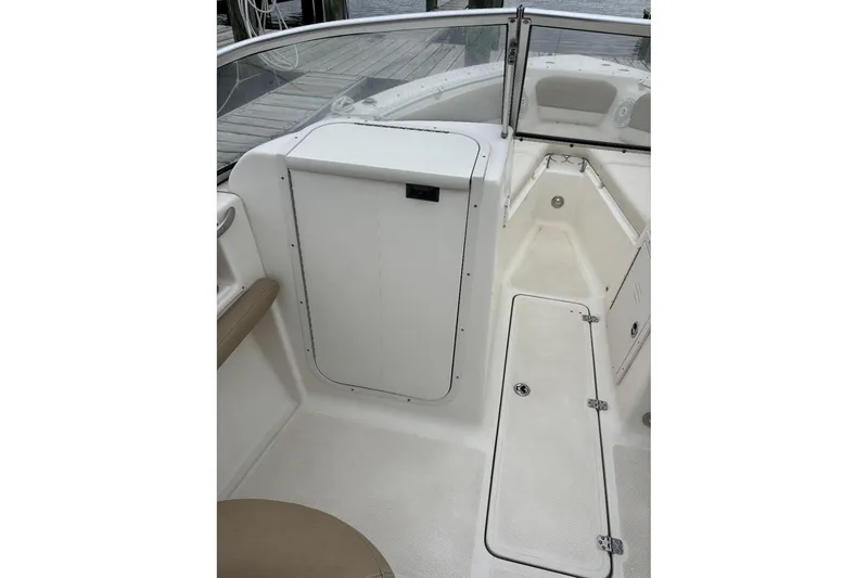 Slide: The Image of 2014 Key West 211 Dual Console boat interior with storage compartments and seating. - 8