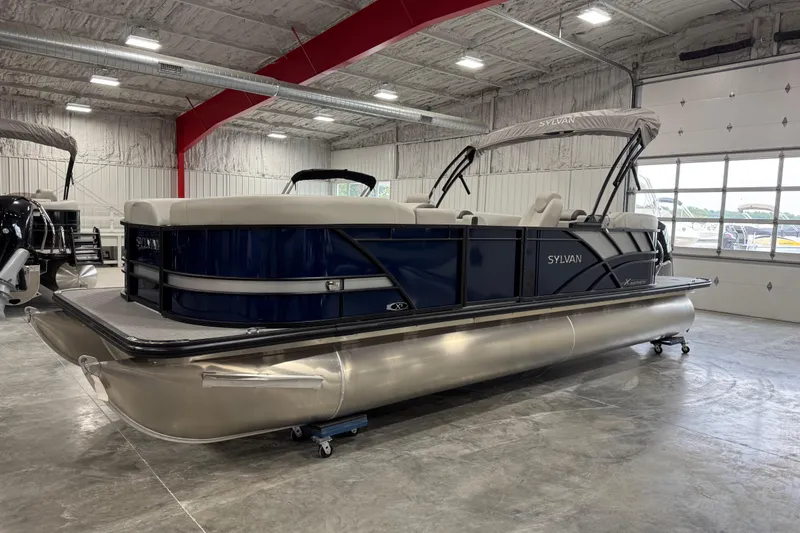 Slide: The Image of 2025 Sylvan X-5 pontoon boat in showroom, featuring sleek design and modern amenities. - 1
