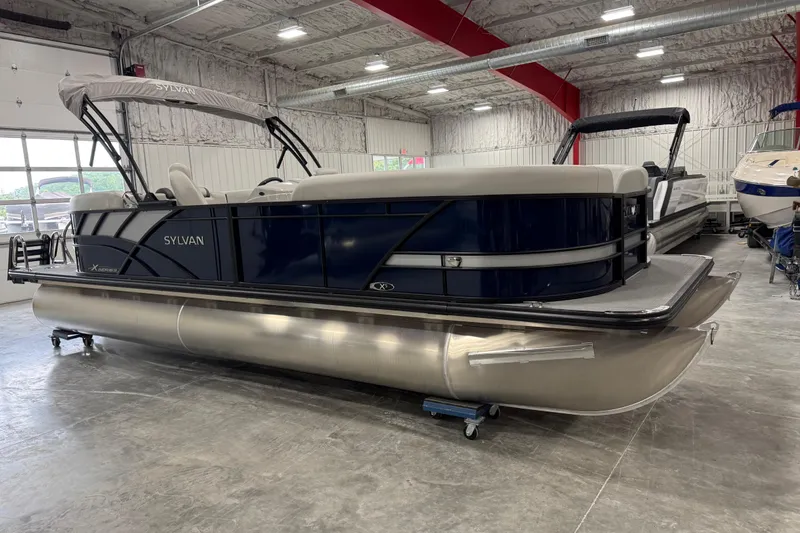 Slide: The Image of 2025 Sylvan X-5 pontoon boat in showroom, featuring sleek design and modern amenities. - 2