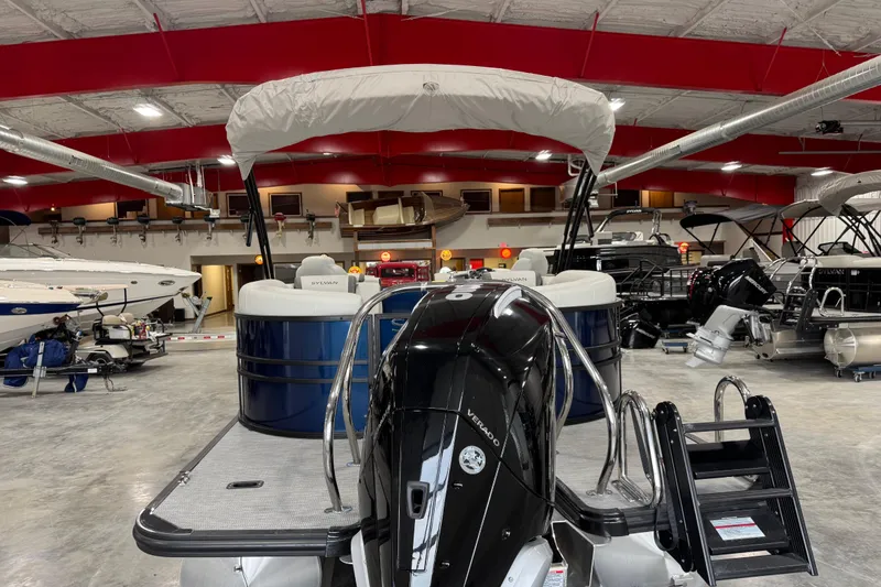 Slide: The Image of 2025 Sylvan X-5 boat in showroom with red ceiling and multiple boats. - 6