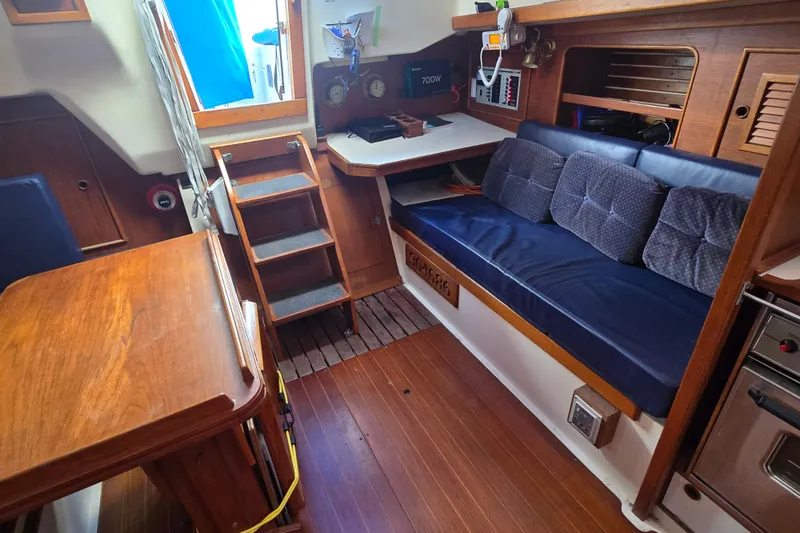 Slide: The Image of Interior of a 1987 Nonsuch 30 Ultra sailboat with wooden furnishings and blue cushions. - 30
