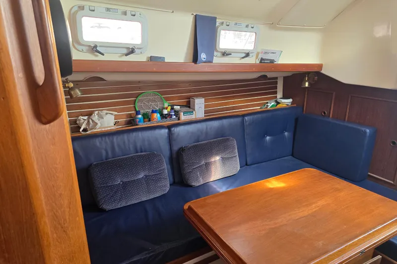 Slide: The Image of Interior of 1987 Nonsuch 30 Ultra sailboat with blue seating and wooden table. - 31
