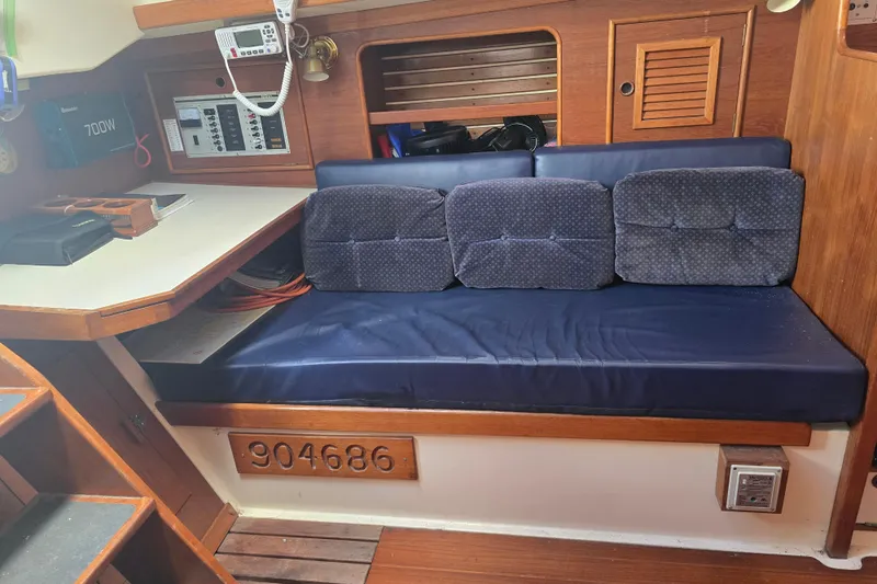 Slide: The Image of Interior of 1987 Nonsuch 30 Ultra sailboat with blue cushioned seating and navigation equipment. - 32