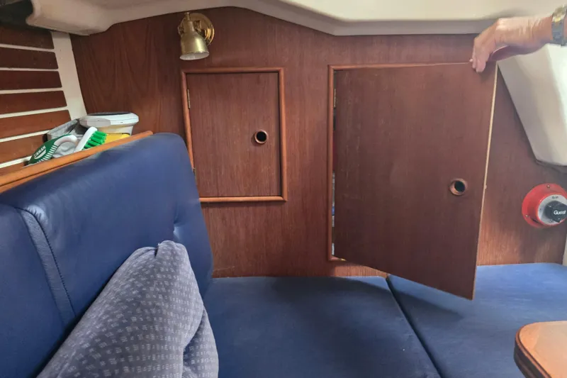 Slide: The Image of Interior of 1987 Nonsuch 30 Ultra sailboat with wooden cabinetry and blue seating. - 33