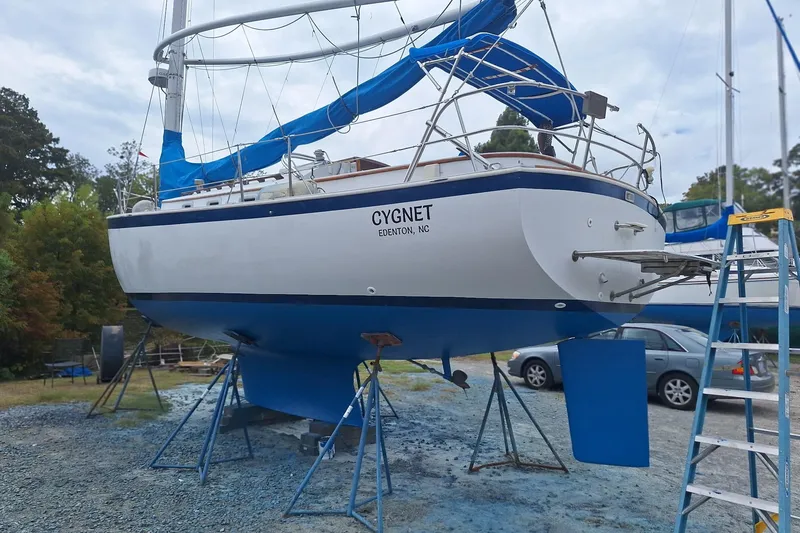Slide: The Image of 1987 Nonsuch 30 Ultra sailboat on land, blue and white hull, named "Cygnet." - 8
