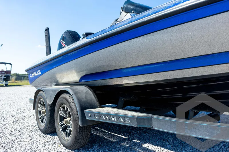 Slide: The Image of 2023 Caymas CX19 boat on trailer, featuring Garmin equipment, parked on gravel. - 13