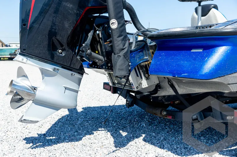 Slide: The Image of 2023 Caymas CX19 boat rear view with motor, parked on gravel lot. - 18