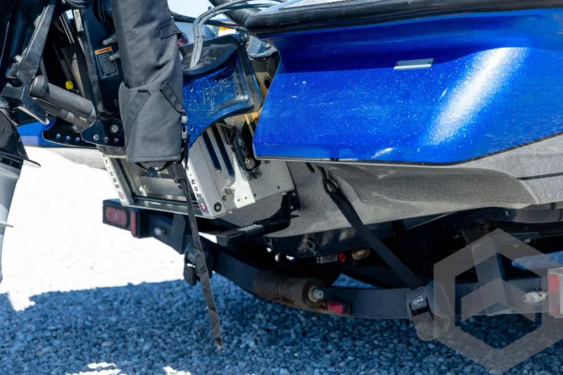 Slide: The Image of 2023 Caymas CX19 boat with dual axle trailer, blue and silver design, powerful outboard motor. - 19