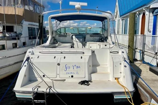 The Image of 1995 Regal Commodore 400 boat docked, rear view, with "Sea Y'all" text on the back. - 1