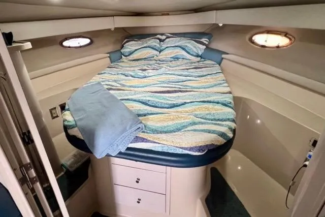 Slide: The Image of Cozy cabin interior of 1995 Regal Commodore 400 with striped bedding and porthole windows. - 11